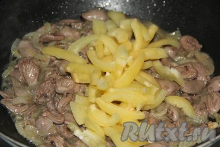 Болгарский перец нарезать полосками. Выложить в сковороду кусочки перца, перемешать, убавить огонь до минимума, накрыть сковороду крышкой и тушить куриные сердечки с овощами минут 15, помешивая время от времени.