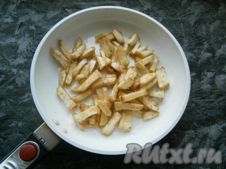 Из болгарского перца удалить семенную коробочку. Лук, чеснок и морковь очистить. Баклажан очистить, нарезать брусочками, выложить в сковороду с растительным маслом.