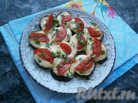 Чтобы закуска стала ярче, сверху украсить баклажаны дольками свежего помидора и посыпать измельченной зеленью.