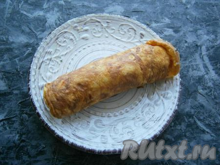 Смазанный яичный корж свернуть в плотный рулет. Рулет с сыром и чесноком завернуть в пищевую плёнку и швом вниз поместить в холодильник на 1 час.