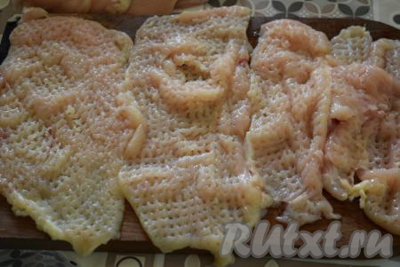 Отбить пласты куриного филе молоточком.
