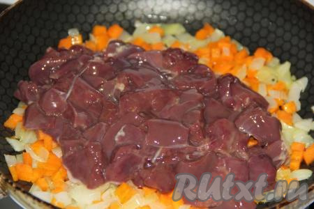 Куриную печень промыть, нарезать на средние кусочки, выложить на сковороду к овощам и, периодически помешивая, обжарить в течение 5-7 минут.
