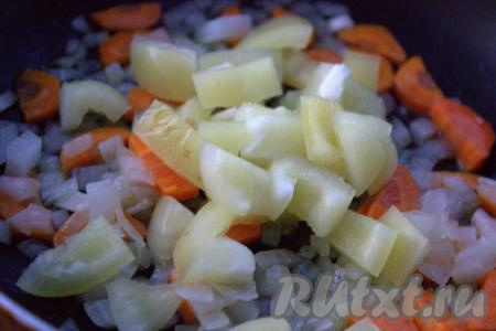 Болгарский перец, очищенный от перегородок и семян, нарезать средними кубиками и выложить в сковороду к луку и моркови, перемешать. Продолжать обжаривать овощи на среднем огне, периодически помешивая, в течение 5-7 минут.