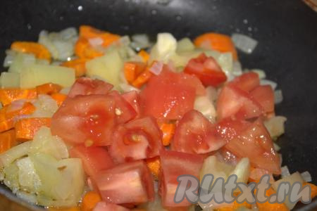 Далее в сковороду добавить помидор, очищенный от кожуры и нарезанный средними кубиками, хорошо перемешать и тушить овощи 3-5 минут на медленном огне, помешивая.