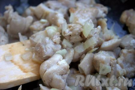 В сковороду к куриному филе добавить репчатый лук, хорошо перемешать, обжаривать 3-5 минут на среднем огне, иногда помешивая.
