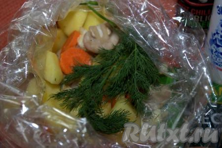 Выложить картошку, шампиньоны, лук и морковку в рукав для запекания, добавить одну веточку укропа и тщательно завязать рукав с двух сторон.
