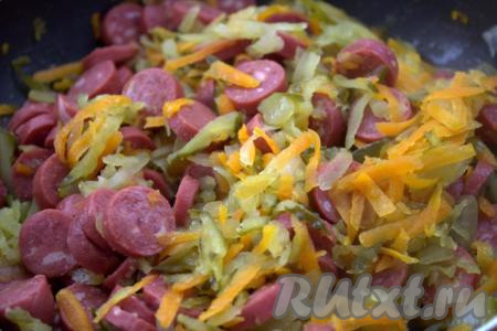 Хорошо перемешать и тушить колбаску с луком, морковью и солёными огурцами, примерно, 5 минут на среднем огне, иногда перемешивая.