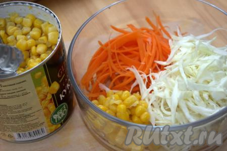 В миске соединить морковь и капусту. С консервированной кукурузы слить жидкость, добавить в миску с салатом из натёртой морковки и нарезанной капусты.