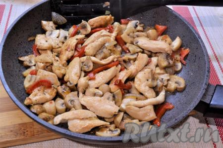 Перемешать и жарить куриное филе с грибами на сковороде на среднем огне, периодически помешивая, около 10 минут. В конце жарки добавить измельчённый чеснок.