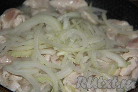 В сковороду с обжаренным куриным мясом выложить лук и обжарить в течение 5-7 минут на среднем огне, иногда перемешивая.