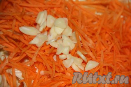 К капусте и моркови добавить очищенный чеснок, нарезанный тонкими пластинками. 