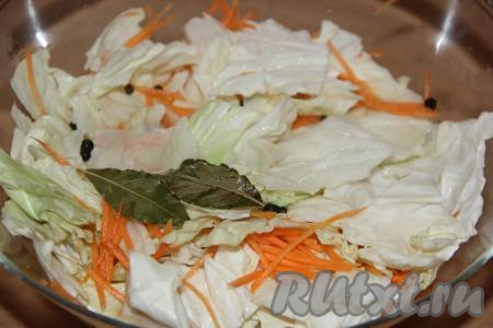 Капусту перемешать с морковью и чесноком, залить горячим маринадом.