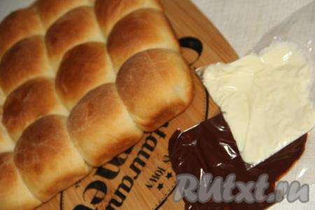 Пирог слегка остудить и переложить на разделочную доску. Теперь можем украсить наш пирог из булочек тёмным и белым шоколадом. Шоколад растопить на водяной бане.