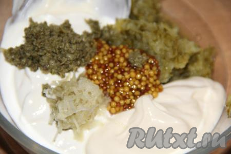 В соус из солёных огурцов, сметаны и майонеза добавить горчицу, нарезанные каперсы, очищенный и пропущенный через пресс чеснок.