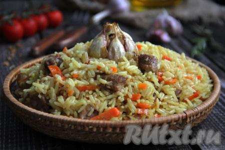 Затем достать из духовки противень с рукавом для запекания. Аккуратно разрезать рукав, разложить вкусный, рассыпчатый и ароматный плов по тарелкам и подать к столу.