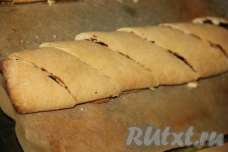 Тёплые рулеты переложить на разделочную доску и нарезать на кусочки.