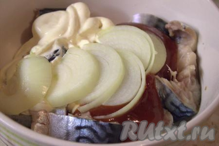 Кусочки рыбки поместить в миску, приправить по вкусу специями, посолить. Добавить к рыбе майонез, кетчуп, очищенный и нарезанный полукольцами лук.