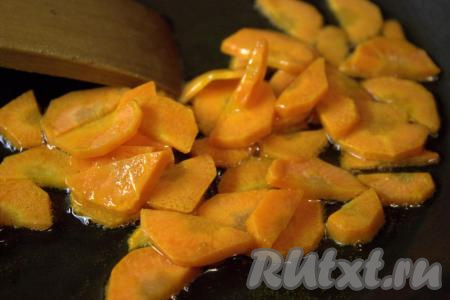 Разогреть в глубокой сковороде 2 столовые ложки растительного масла, затем выложить морковь и обжаривать её в течение 3-4 минут на среднем огне, периодически помешивая.