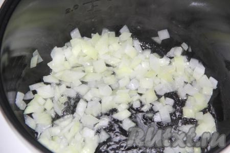 Морковь и лук очистить. Влить в чашу мультиварки 3 столовые ложки растительного масла и выставить режим "Жарка" на 15 минут. Выложить мелко нарезанный лук в мультиварку и обжарить в течение 5 минут, периодически помешивая, не закрывая крышку мультиварки.