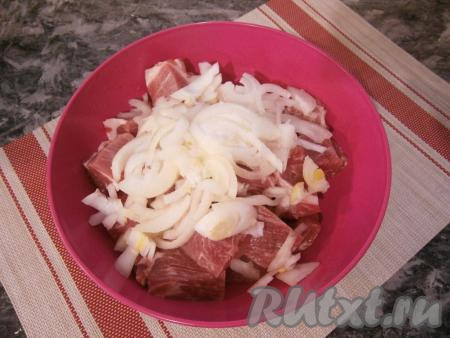 Репчатый лук очистить, нарезать его полукольцами, выложить на мясо. Сверху лук посолить и хорошо помять руками, после чего перемешать его с мясом.
