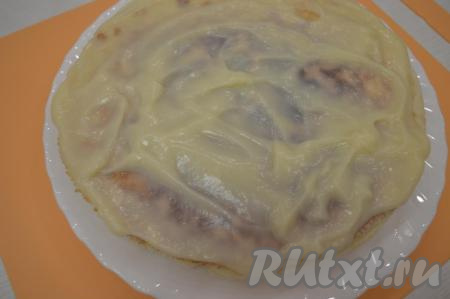 В горячий крем выложить размягчённое сливочное масло, нарезанное на кусочки, и перемешать венчиком. Заварной крем полностью готов. Собрать торт, хорошо промазывая каждый остывший корж достаточно большим количеством тёплого крема, а затем складывая 8 коржей друг на друга. 