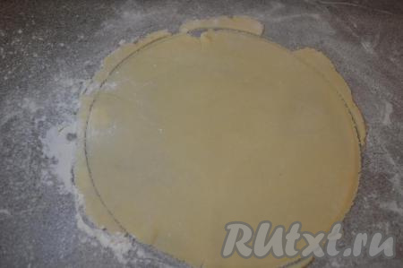 На столе, припылённом мукой, раскатать скалкой одну часть теста в круг. Я обычно раскатываю коржи диаметром 22 см (размер коржа должен быть меньше диаметра сковороды, на которой вы планируете его готовить). Тесто легко раскатывается. Для того чтобы корж получился более ровным, поверх раскатанного теста я кладу тарелку диаметром 22 см и лишнее тесто обрезаю ножом. Обрезанного теста получается немного, отложите его в сторону оно потребуется в дальнейшем.