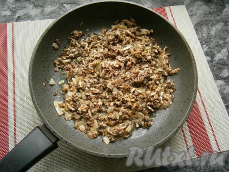 Далее в сковороду выложить натёртые шампиньоны, перемешать с луком и жарить на среднем огне, иногда помешивая, пока не испарится вся жидкость (около 4-5 минут).