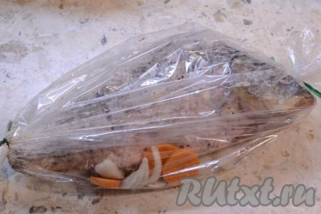 Аккуратно расположить рыбу поверх овощей в рукаве для запекания. Тщательно завязать рукав с двух сторон.