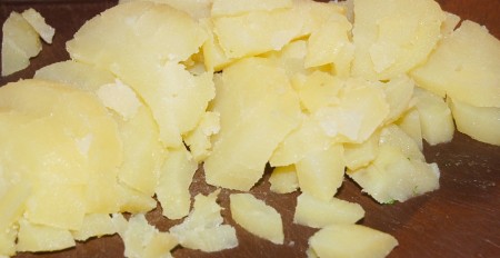 Картофель отварить в мундире, охладить, почистить, нарезать небольшими кубиками.
