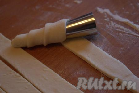 Начиная с зауженной части конуса, накрутить полоску теста внахлёст (как показано на фото) и закрепить тесто у основания конуса (у меня металлические конусы длиной 9 см и диаметром 3,5 см).
