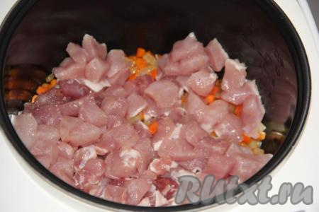 Мякоть свинины нарезать на кубики среднего размера и выложить в чашу мультиварки к обжаренным овощам.