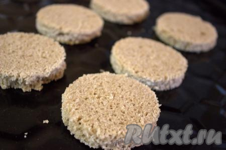 На сухой противень выложить подготовленные кружочки хлеба и поставить в духовку, разогретую до 180 градусов, минут на 7. Затем кружочки перевернуть на другую сторону и подсушить ещё 2 минуты.