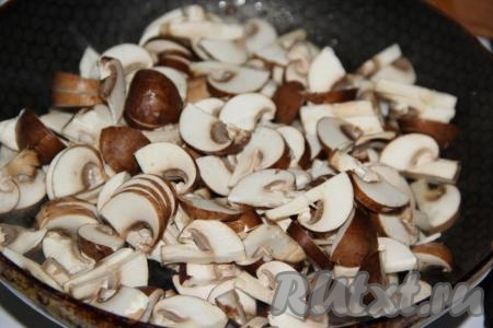 Шампиньоны предварительно промыть под водой, нарезать на пластинки и выложить на сковороду с растительным маслом.