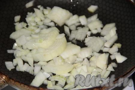 Влить растительное масло в сковороду, добавить предварительно очищенный и мелко нарезанный репчатый лук.