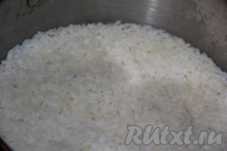 Разморозить при комнатной температуре крабовые палочки. Рис предварительно промыть проточной водой (промывать до прозрачности воды). 100 грамм промытого риса выложить в кастрюлю, залить 200 мл холодной воды, поставить на огонь. Дать закипеть, а затем, сделав огонь минимальным, варить под закрытой крышкой минут 20 (до полного испарения воды). Как только вода испарится, снять кастрюлю с огня и добавить рисовый уксус, перемешать и, накрыв кастрюлю полотенцем, полностью остудить.