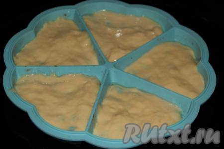 Выложить в каждую ячейку по 1 столовой ложке теста и слегка распределить его.