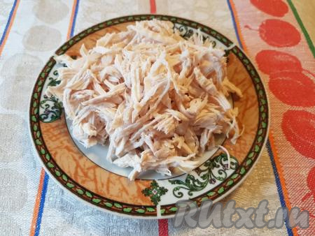 Куриное мясо разделить на волокна.