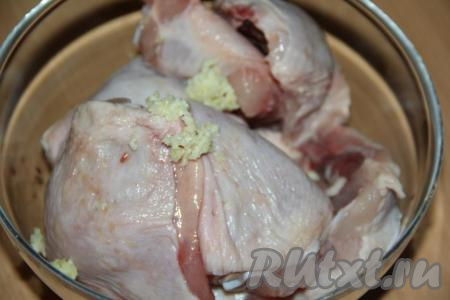 К кусочкам курицы добавить очищенные и пропущенные через пресс зубчики чеснока.
