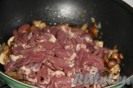 Разрезать куриные сердечки пополам и тщательно промыть от сгустков крови. Выложить сердечки в сковороду к грибам и луку.