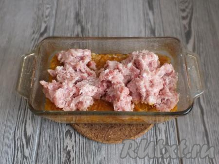 Через 1 час 15 минут достаньте форму с перловкой и овощами из духовки. Жидкость заметно впитается в крупу. Сверху распределите фарш.