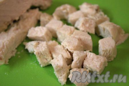 Готовое куриное мясо достать из бульона, а после остывания нарезать на кубики размером, примерно, 1 на 1 сантиметр.
