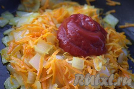 В глубокой сковороде с толстым дном разогреть растительное масло, выложить лук и обжарить его до мягкости (минут 5) на среднем огне, иногда помешивая. Затем в сковороду к луку добавить морковку, обжаривать овощи в течение 3-4 минут, не забывая помешивать. Добавить к обжаренным овощам томатную пасту, хорошо перемешать. 