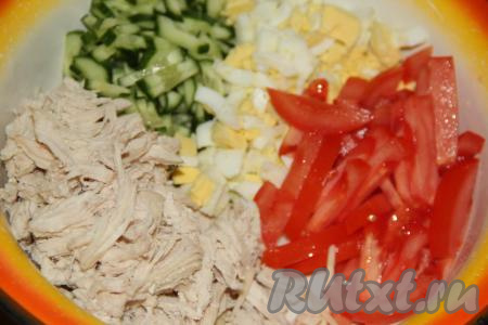 Помидор вымыть, нарезать на длинные дольки и тоже выложить в салат из курицы, яиц и огурца.