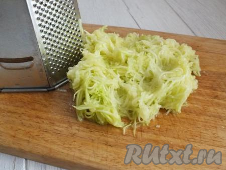 Для приготовления курино-кабачковых оладий желательно брать молоденький кабачок с мелкими семечками. Снимите с кабачка кожуру (если семечки крупные, их нужно будет удалить), натрите на мелкой тёрке. Из натёртых кабачков отожмите руками сок, он нам не пригодится.