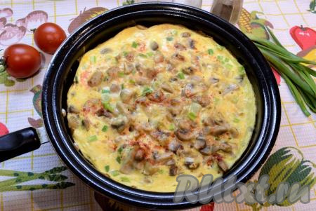 Прикрыть сковороду крышкой и на медленном огне готовить омлет с шампиньонами до тех пор, пока сверху он не перестанет быть жидким (3-5 минут).