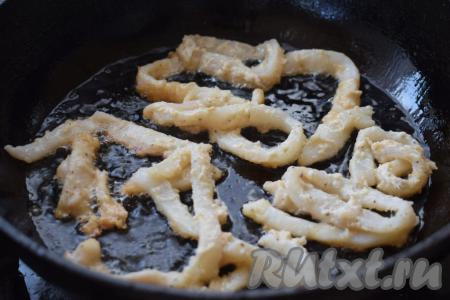 В сковороде разогреваем растительное масло на среднем огне. Далее небольшими партиями выкладываем кольца кальмаров в кляре и жарим на среднем огне, примерно, 3-4 минуты, периодически помешивая.