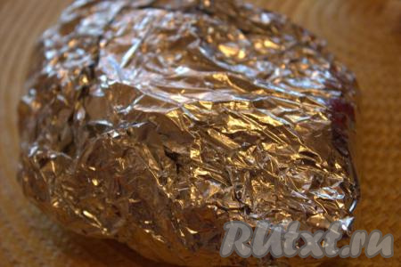 Плотно накрыть куриное филе с чесноком другим листом фольги и хорошо завернуть, чтобы получился "конвертик" из фольги. Запекать куриное филе минут 30 в духовке, заранее разогретой до 200 градусов.