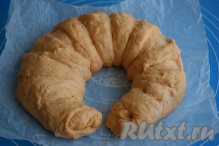 Берём пергамент размером с форму и аккуратно перекладываем на него наш хлеб. Для приготовления этого хлеба я использовала форму диаметром 26 см, сворачивая тесто калачиком.
