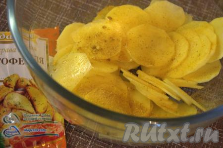 В глубокую миску поместить нарезанный кружочками картофель, посолить, добавить универсальную приправу для картошки (можно использовать любые специи по вашему вкусу), влить оливковое (или растительное) масло, тщательно перемешать.
