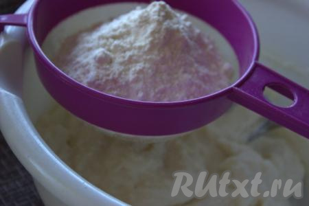 Часть муки смешать с разрыхлителем, просеять через сито, добавить в миску к творожной массе, перемешать. Остальную муку добавлять небольшими порциями (муки может понадобиться чуть больше или меньше - это зависит от влажности творога), замешивая творожное тесто вначале ложкой, а затем - руками.
